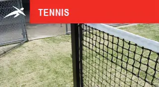 Close-up view of an outdoor tennis net and tennis posts on a grass court. A red banner at the top reads “TENNIS” with HiTech’s logo.